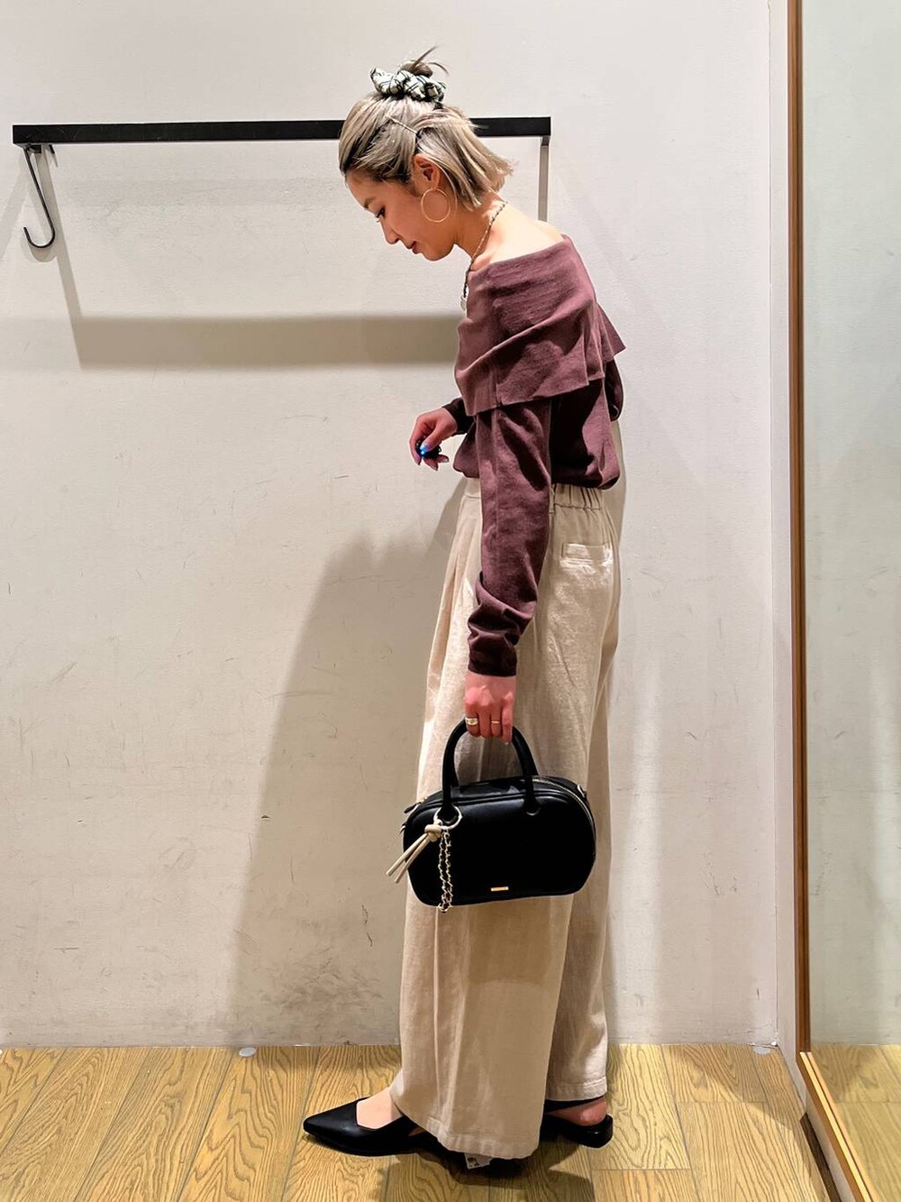 ブラック系のハンドバッグ、ベージュ系のその他パンツを着用したレディースの春コーディネートの3枚目の写真