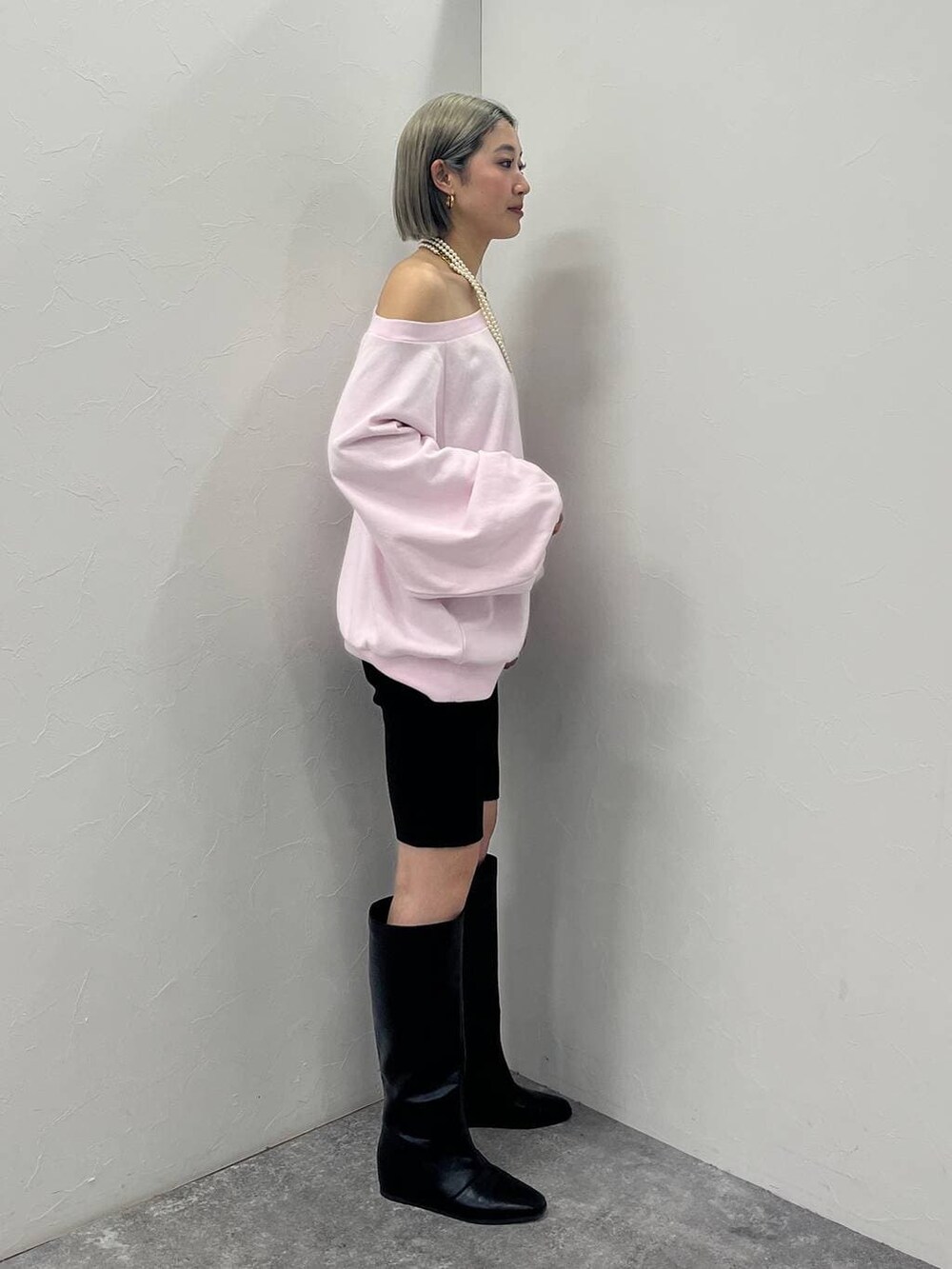 ブラック系のブーツ、ブラック系のその他パンツ、ピンク系のスウェットを着用したレディースの冬コーディネートの3枚目の写真