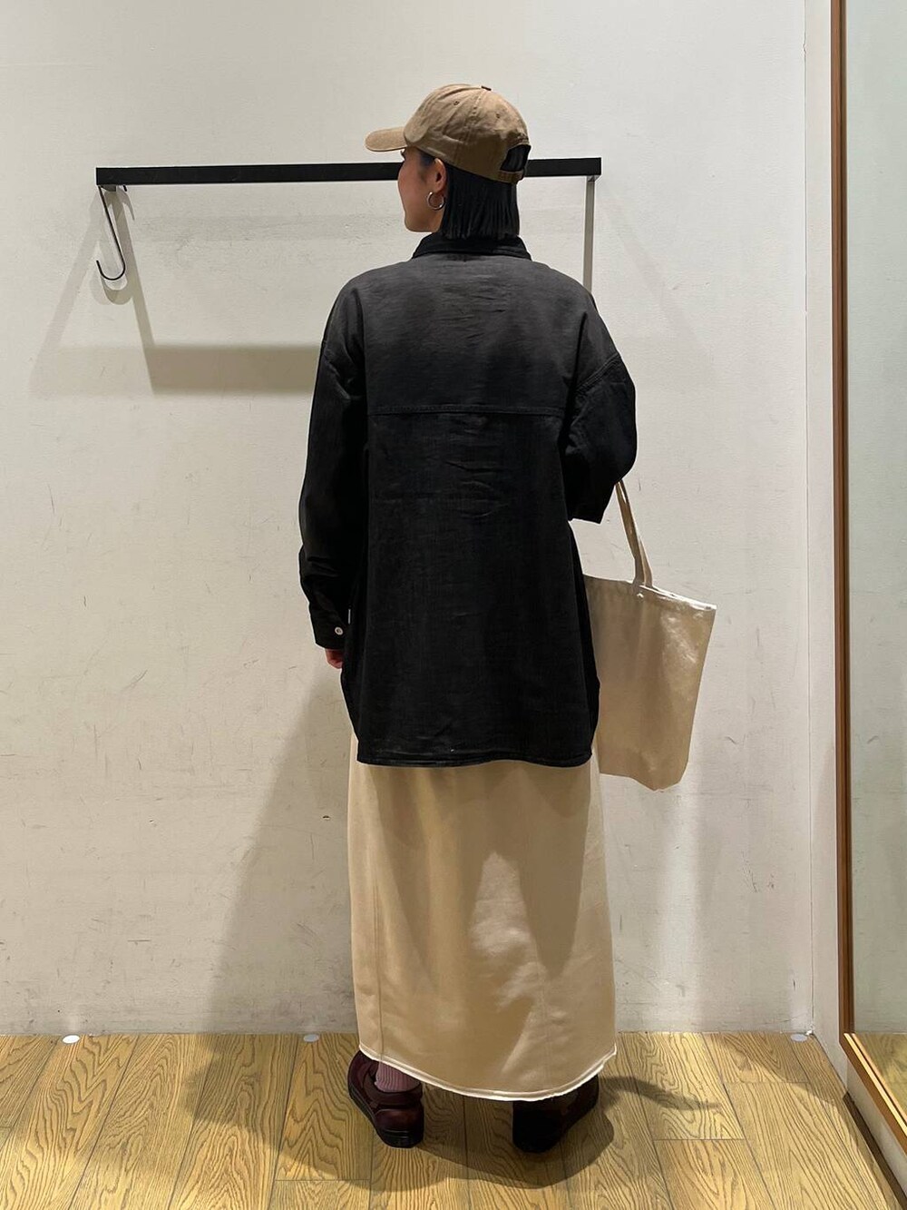 ベージュ系のスカート、ブラック系のシャツ/ブラウス、ベージュ系のトートバッグを着用したレディースの冬コーディネートの4枚目の写真