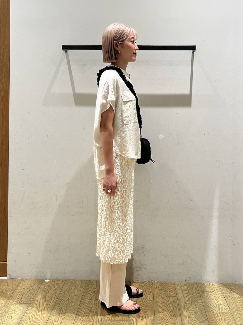 ホワイト系のその他パンツ、ホワイト系のシャツ/ブラウス、ブラック系のサンダルを着用したレディースの夏コーディネートの2枚目の写真