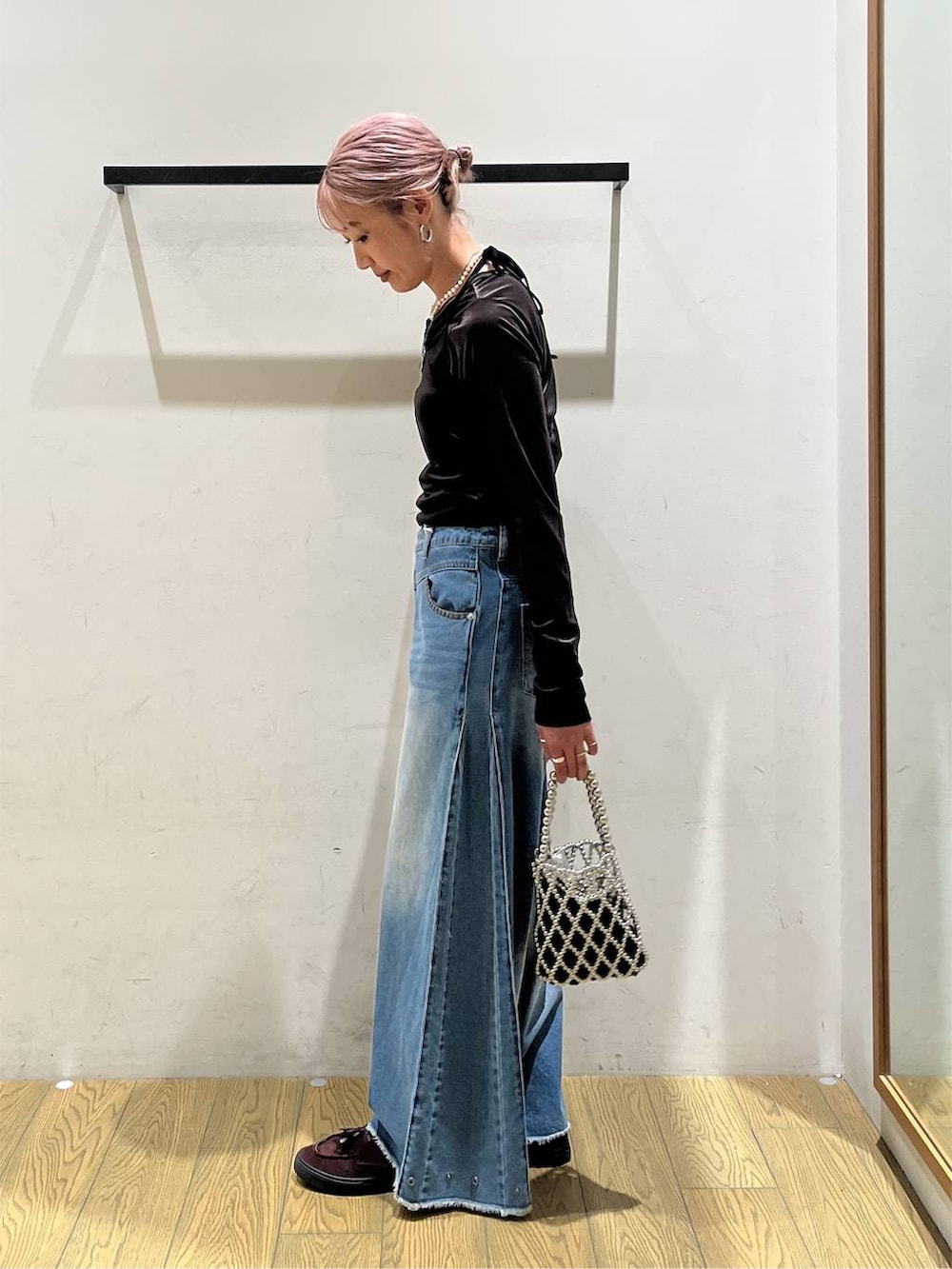 シルバー系のショルダーバッグ、グレー系のカーディガン/ボレロ、ブルー系のデニムパンツを着用したレディースの秋コーディネートの3枚目の写真