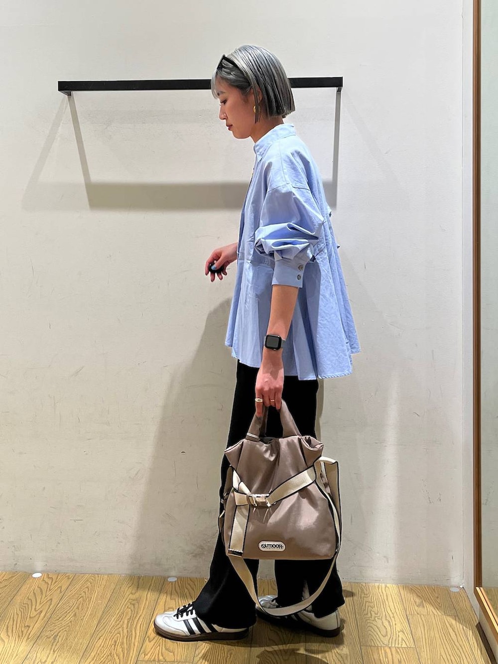 グリーン系のトートバッグ、ブラック系のその他パンツ、ブルー系のシャツ/ブラウスを着用したレディースの春コーディネートの2枚目の写真