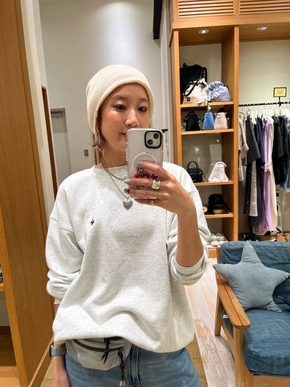ブルー系のデニムパンツ、ブルー系のショルダーバッグ、グレー系のスウェットを着用したレディースの秋コーディネートの2枚目の写真