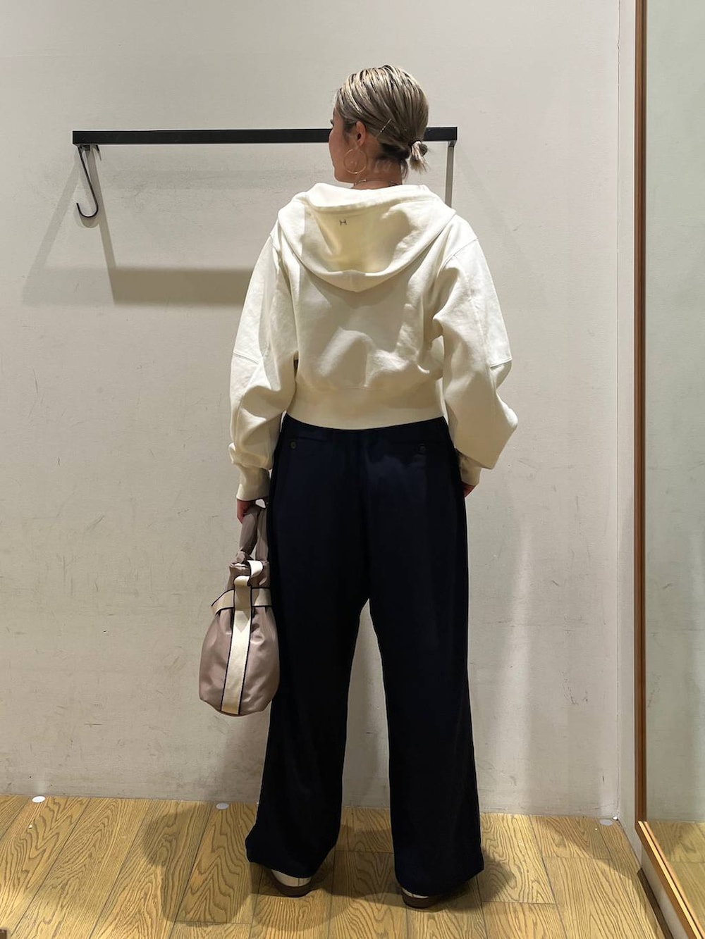 グリーン系のトートバッグ、ブルー系のその他パンツ、ベージュ系のパーカーを着用したレディースの春コーディネートの4枚目の写真