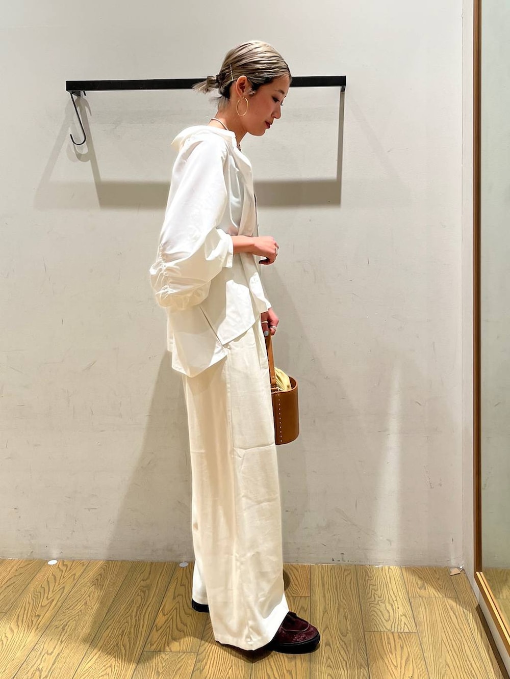 イエロー系のハンドバッグ、ベージュ系のその他パンツ、ホワイト系のシャツ/ブラウスを着用したレディースの春コーディネートの3枚目の写真