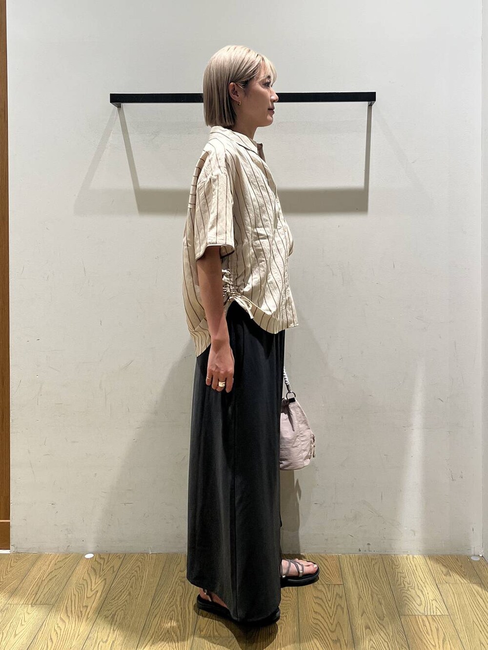 ベージュ系のショルダーバッグ、ベージュ系のシャツ/ブラウス、グレー系のスカートを着用したレディースの夏コーディネートの2枚目の写真