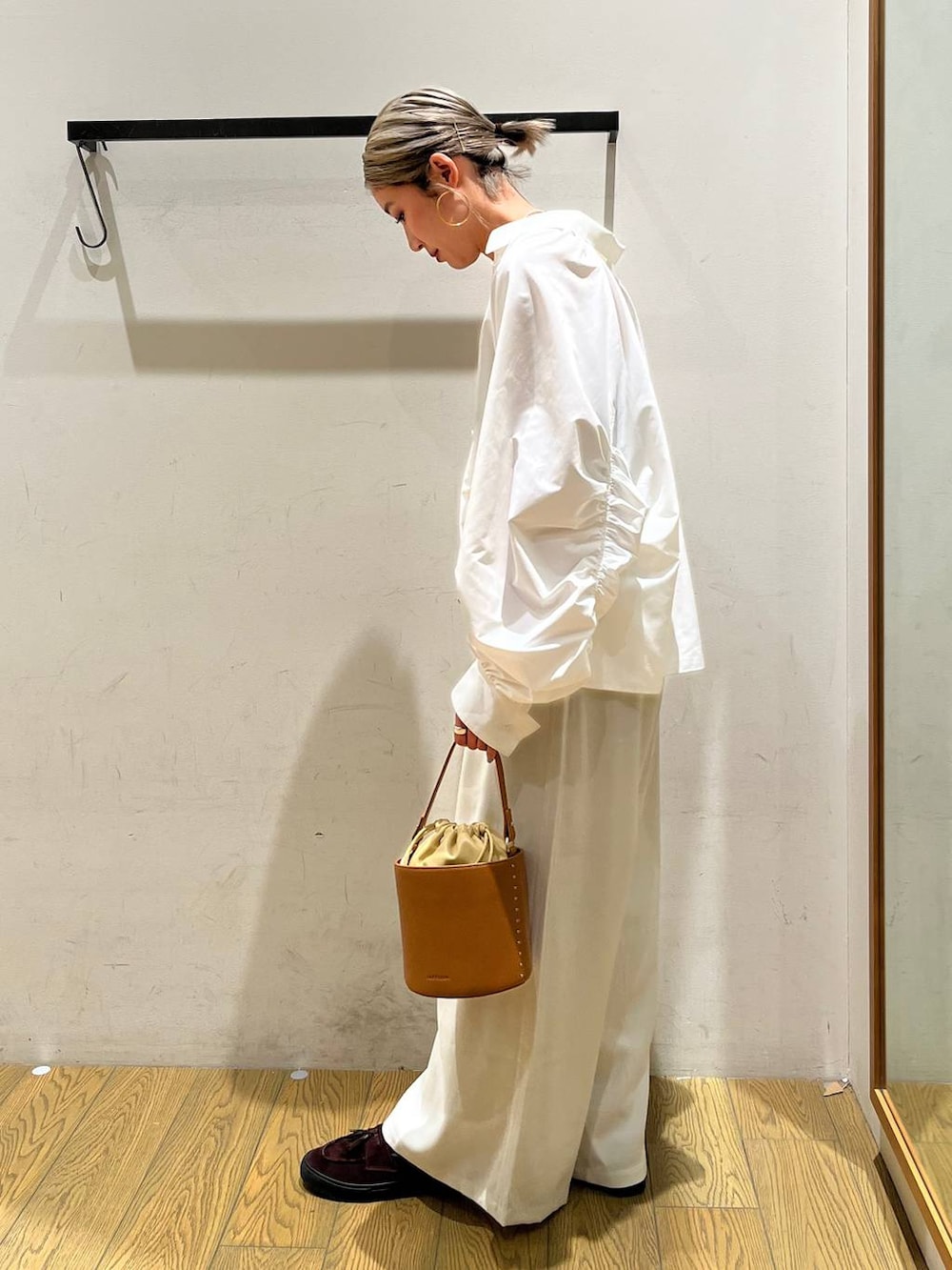 イエロー系のハンドバッグ、ベージュ系のその他パンツ、ホワイト系のシャツ/ブラウスを着用したレディースの春コーディネートの2枚目の写真