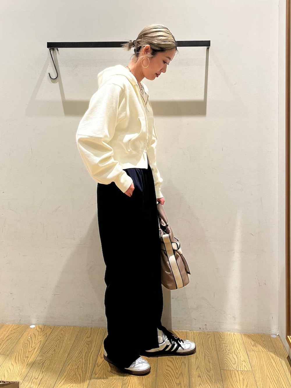 グリーン系のトートバッグ、ブルー系のその他パンツ、ベージュ系のパーカーを着用したレディースの春コーディネートの3枚目の写真