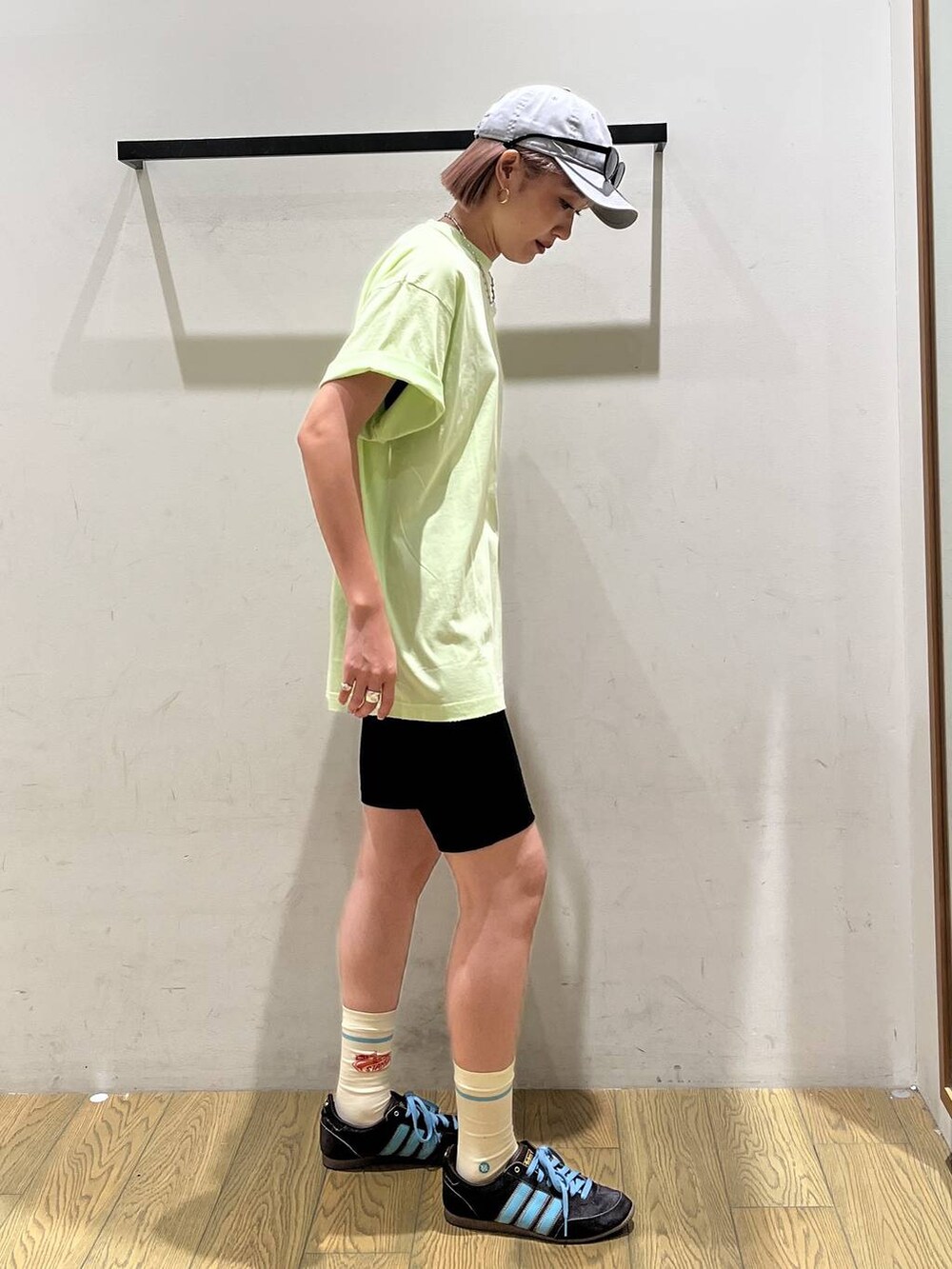 グリーン系のTシャツ/カットソー、グレー系のキャップ、ブラック系のサングラスを着用したレディースの夏コーディネートの3枚目の写真