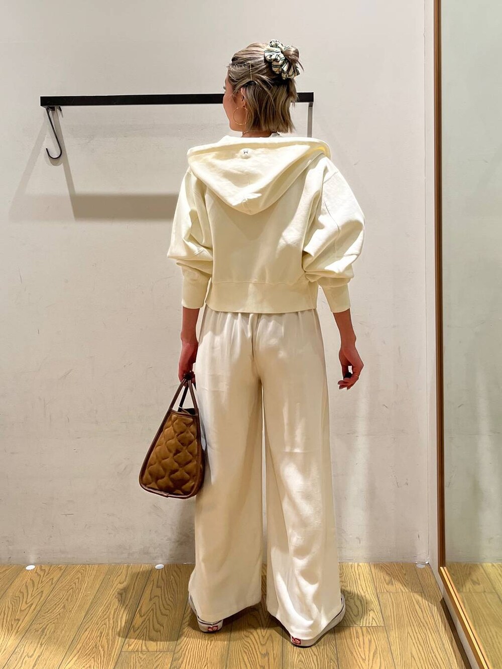イエロー系のハンドバッグ、ベージュ系のその他パンツ、ホワイト系のTシャツ/カットソーを着用したレディースの春コーディネートの4枚目の写真