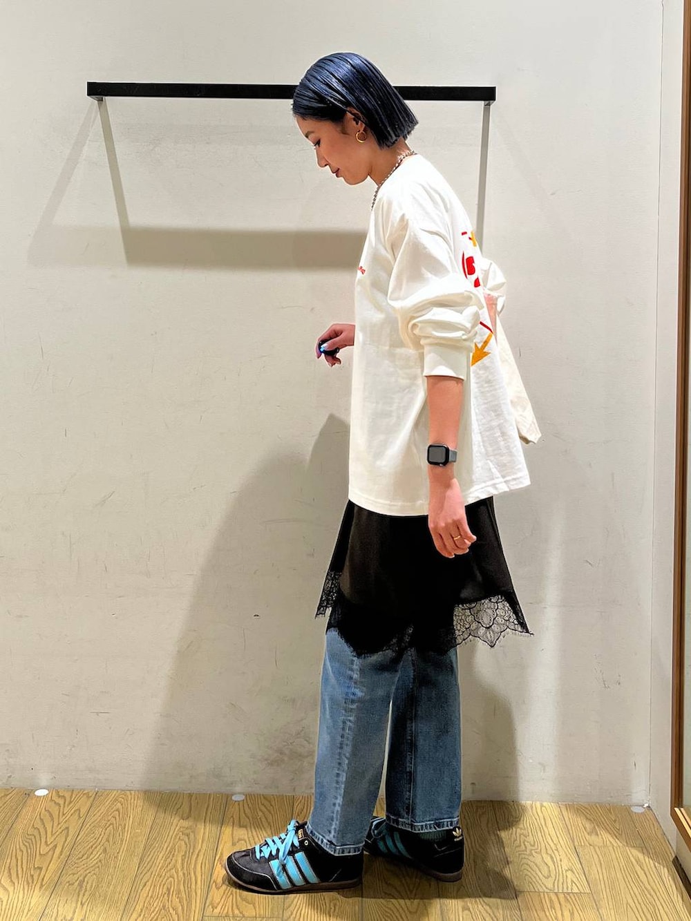 ブルー系のデニムパンツ、グレー系のワンピース、ベージュ系のトートバッグを着用したレディースの冬コーディネートの3枚目の写真