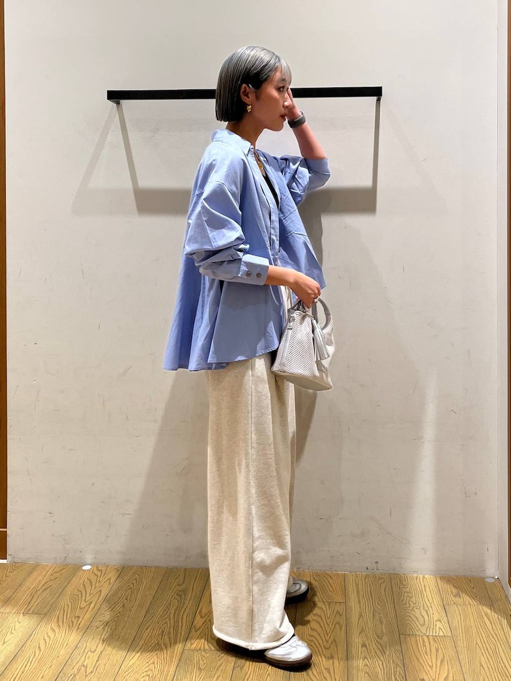 グレー系のショルダーバッグ、ブルー系のシャツ/ブラウス、ブラック系のブラジャーを着用したレディースの春コーディネートの3枚目の写真