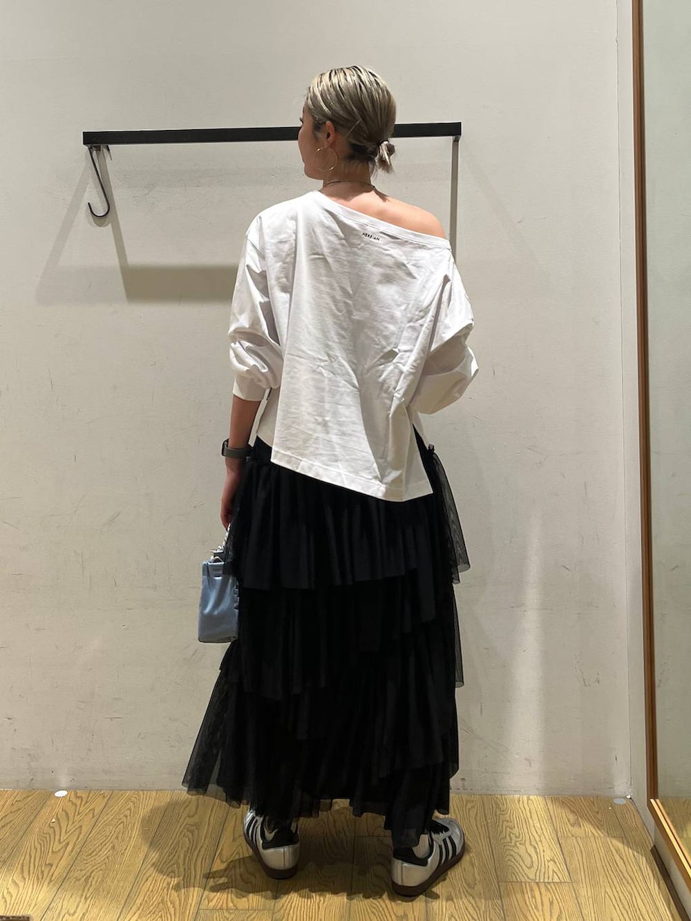 ホワイト系のTシャツ/カットソー、ブルー系のショルダーバッグ、ブラック系のスカートを着用したレディースの春コーディネートの4枚目の写真