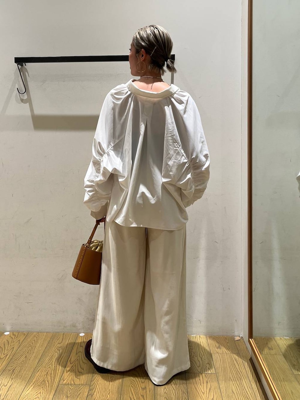 イエロー系のハンドバッグ、ベージュ系のその他パンツ、ホワイト系のシャツ/ブラウスを着用したレディースの春コーディネートの4枚目の写真