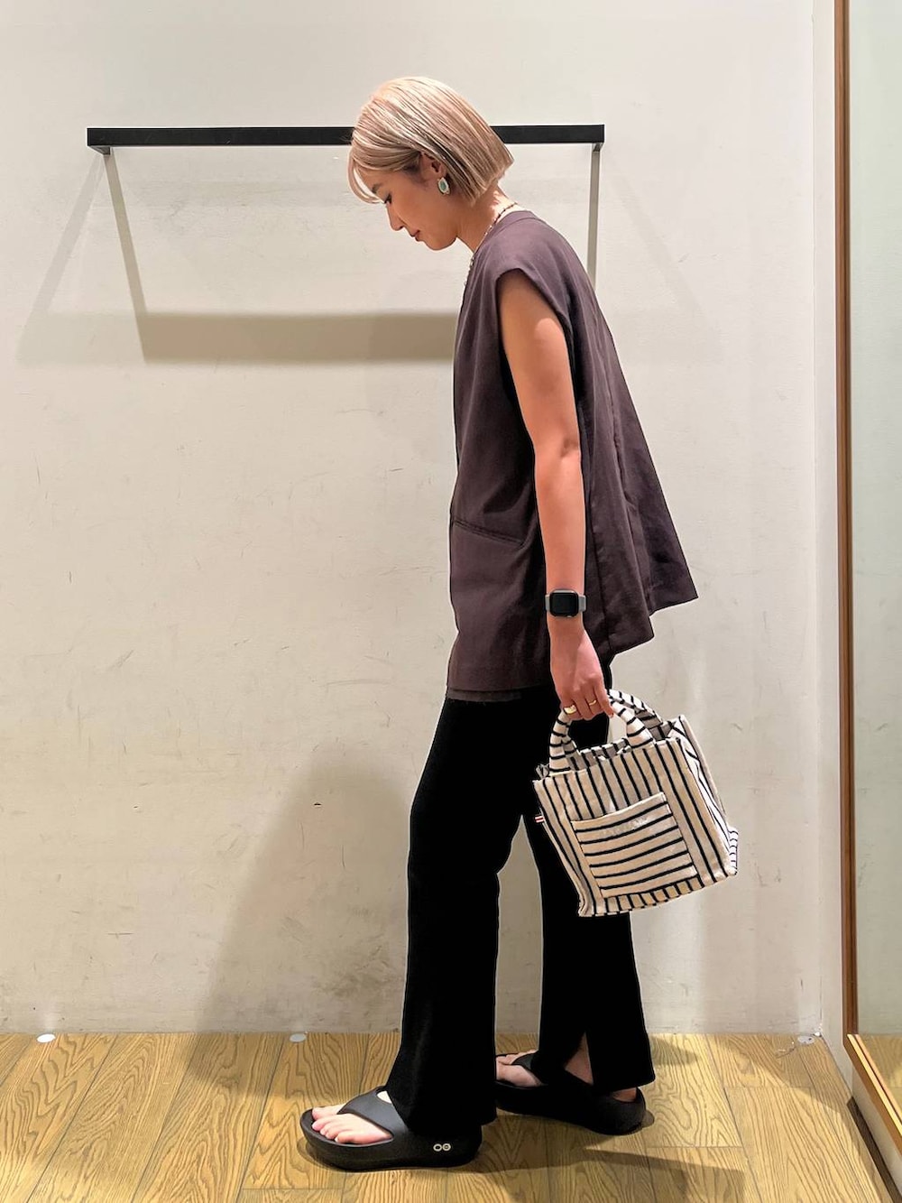 ブラック系のその他パンツ、ブラウン系のタンクトップ、ベージュ系のトートバッグを着用したレディースの春コーディネートの2枚目の写真