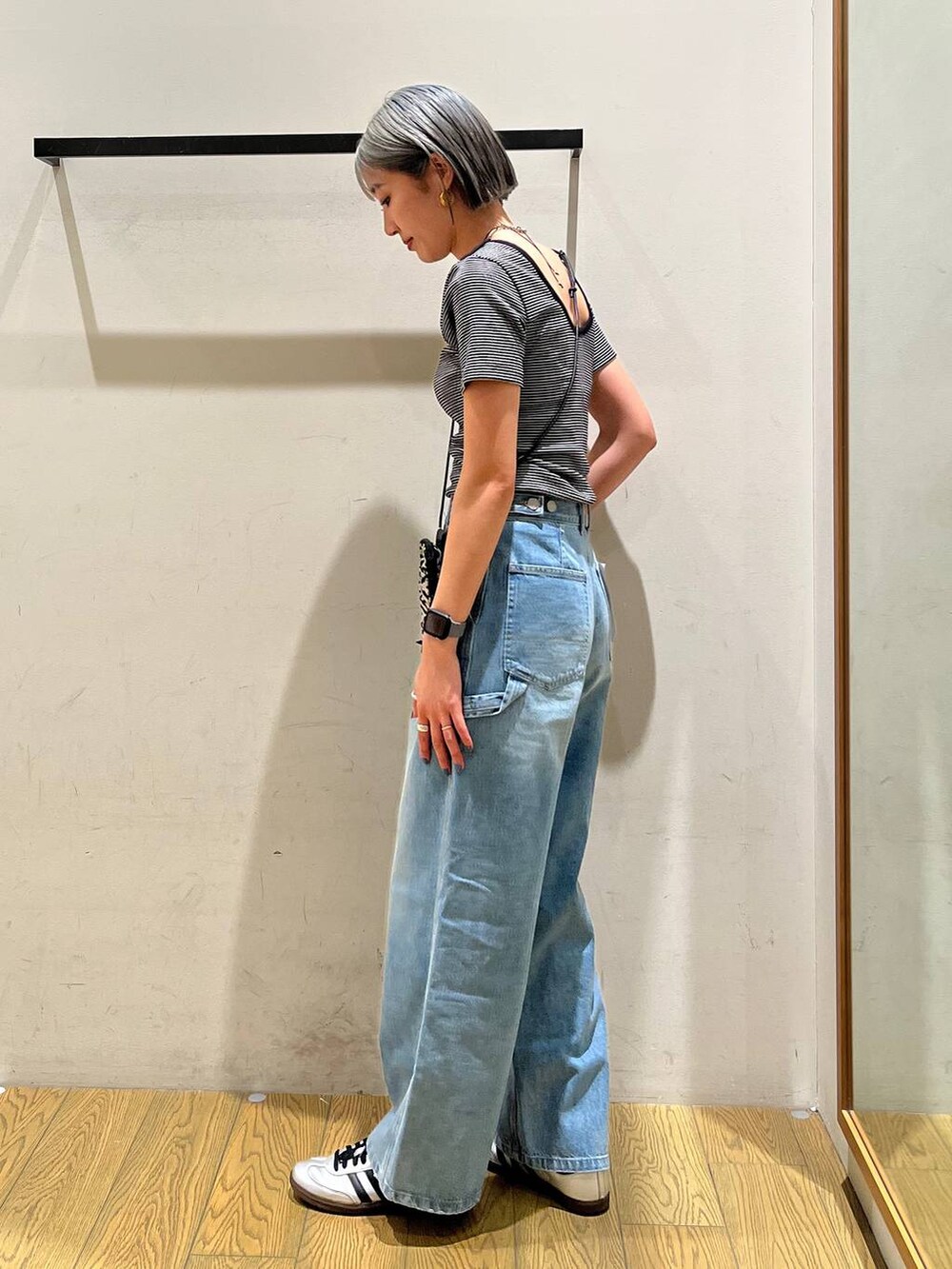 ベージュ系のショルダーバッグ、ブルー系のデニムパンツ、ブラック系のTシャツ/カットソーを着用したレディースの春コーディネートの2枚目の写真