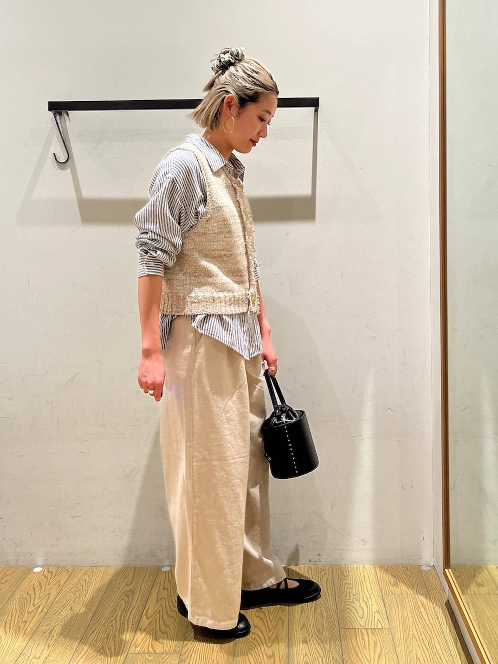 ブルー系のシャツ/ブラウス、ブラック系のハンドバッグ、ブラック系のバレエシューズを着用したレディースの春コーディネートの2枚目の写真