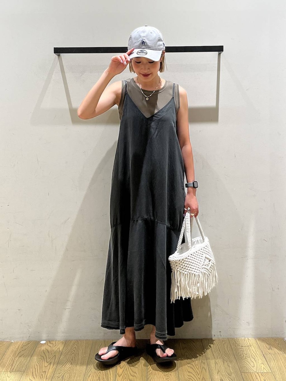 ベージュ系のトートバッグ、ブラウン系のTシャツ/カットソー、ブラック系のサンダルを着用したレディースの夏コーディネートの5枚目の写真