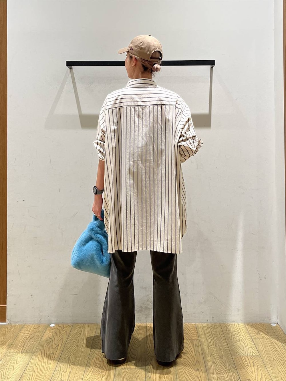ベージュ系のチュニック、グレー系のその他パンツ、ブルー系のハンドバッグを着用したレディースの秋コーディネートの4枚目の写真