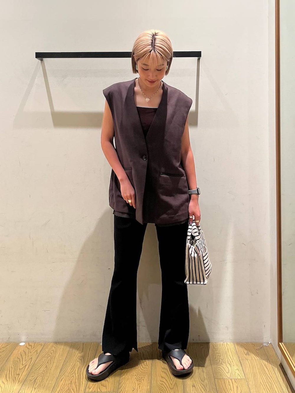 ブラック系のその他パンツ、ブラウン系のタンクトップ、ベージュ系のトートバッグを着用したレディースの春コーディネートの6枚目の写真