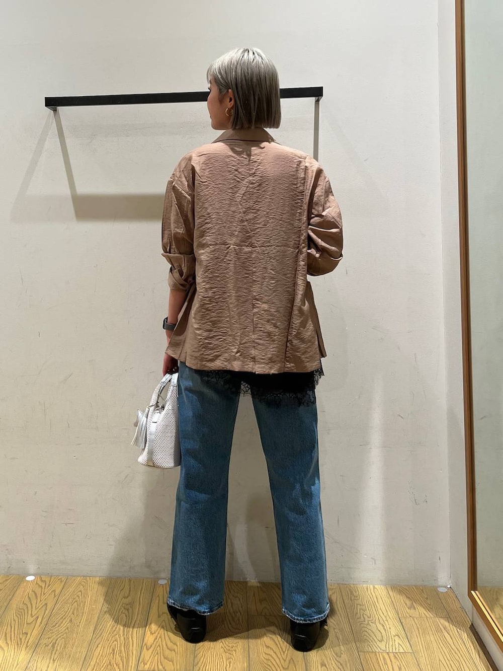 ブルー系のデニムパンツ、ブラック系のバレエシューズ、グレー系のショルダーバッグを着用したレディースの春コーディネートの4枚目の写真