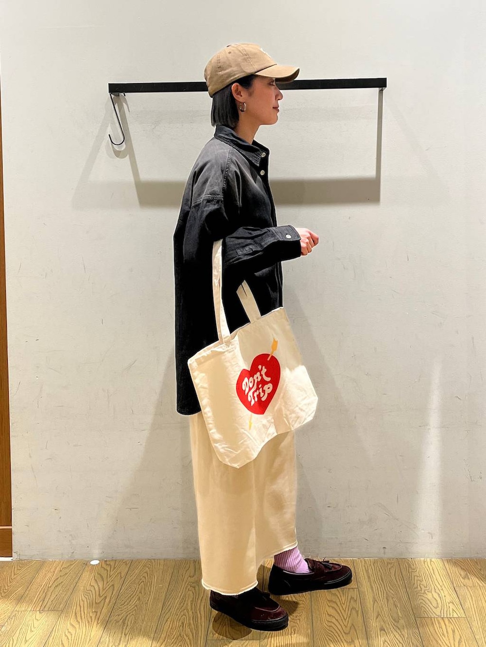 ベージュ系のスカート、ブラック系のシャツ/ブラウス、ベージュ系のトートバッグを着用したレディースの冬コーディネートの2枚目の写真