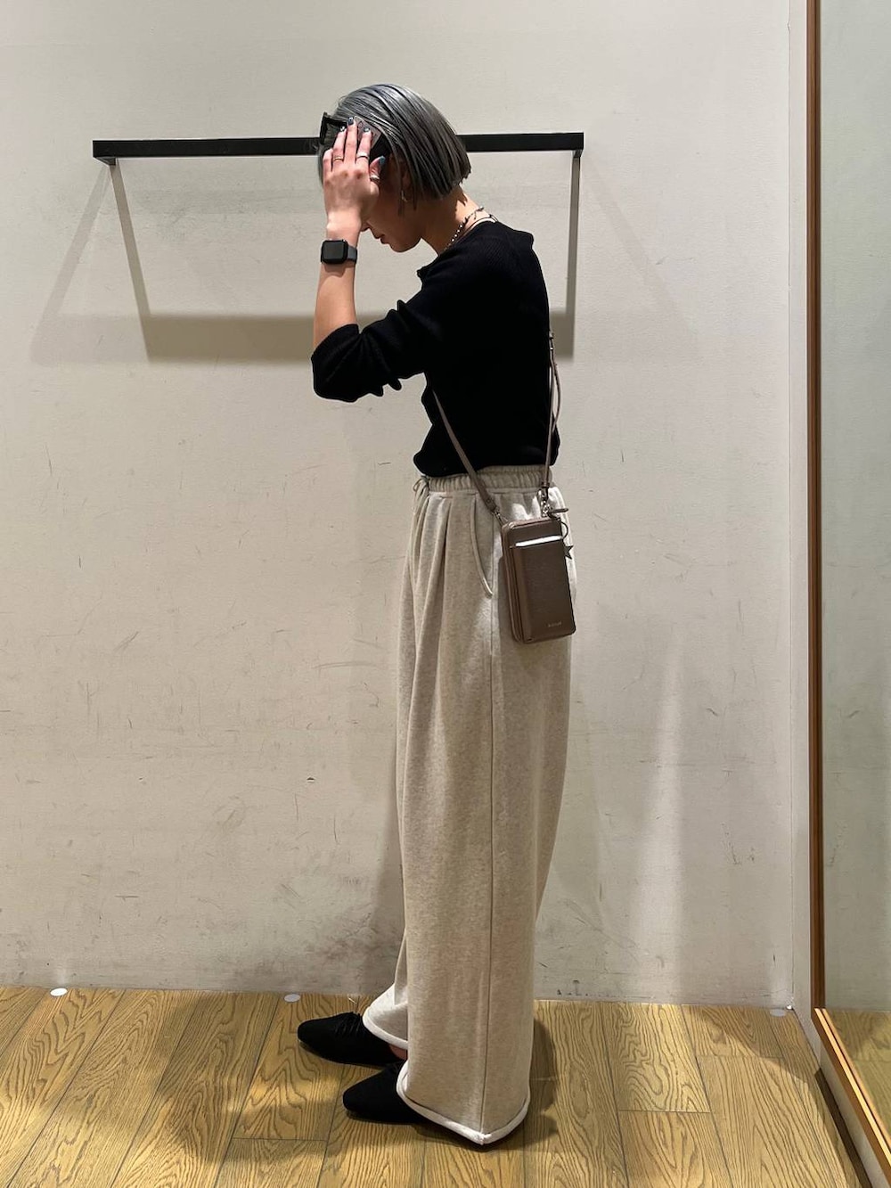 ブラック系のサンダル、ブラック系のカーディガン/ボレロ、ブラウン系の財布を着用したレディースの春コーディネートの2枚目の写真