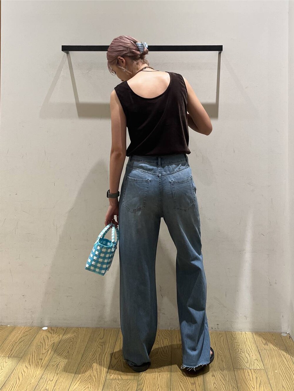 ブルー系のデニムパンツ、ブルー系のハンドバッグ、ブラウン系のネックレスを着用したレディースの夏コーディネートの4枚目の写真