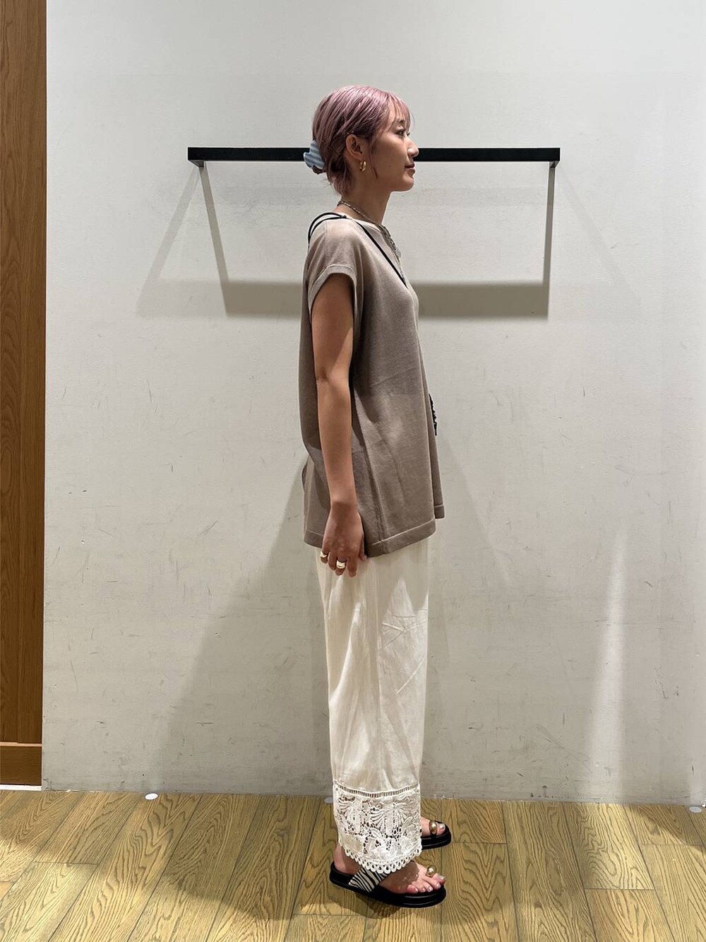 ベージュ系のニット/セーター、ホワイト系のその他パンツ、ベージュ系のショルダーバッグを着用したレディースの夏コーディネートの2枚目の写真