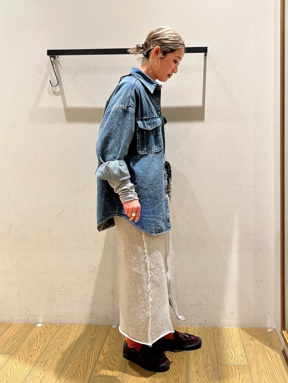 ベージュ系のショルダーバッグ、グレー系のスカート、ブルー系のシャツ/ブラウスを着用したレディースの春コーディネートの2枚目の写真