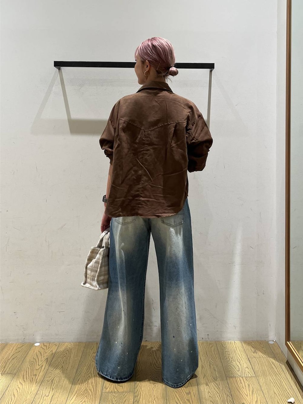 ブラウン系のシャツ/ブラウス、ベージュ系のトートバッグ、ブルー系のデニムパンツを着用したレディースの秋コーディネートの4枚目の写真