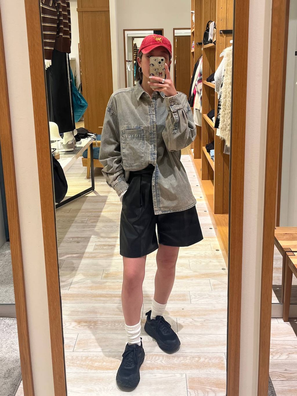 ブラック系のその他パンツ、ブルー系のシャツ/ブラウス、レッド系のキャップを着用したレディースの冬コーディネートの3枚目の写真