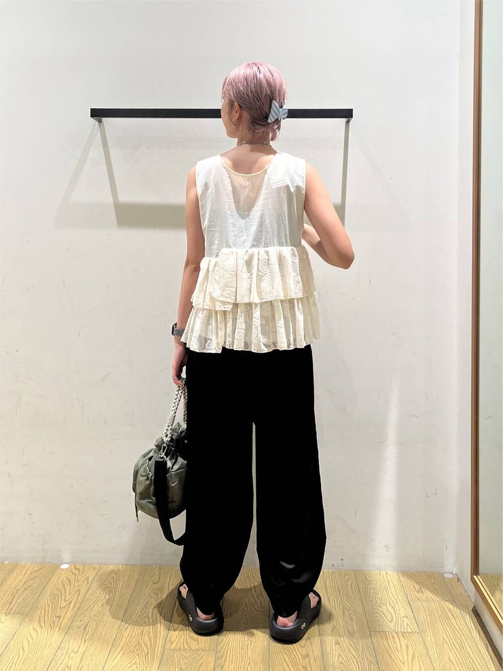 ブラック系のその他パンツ、ホワイト系のベスト、ブラック系のサンダルを着用したレディースの夏コーディネートの4枚目の写真