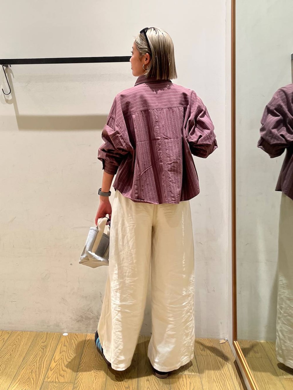 グレー系のトートバッグ、ブラウン系のシャツ/ブラウス、ベージュ系のその他パンツを着用したレディースの春コーディネートの2枚目の写真