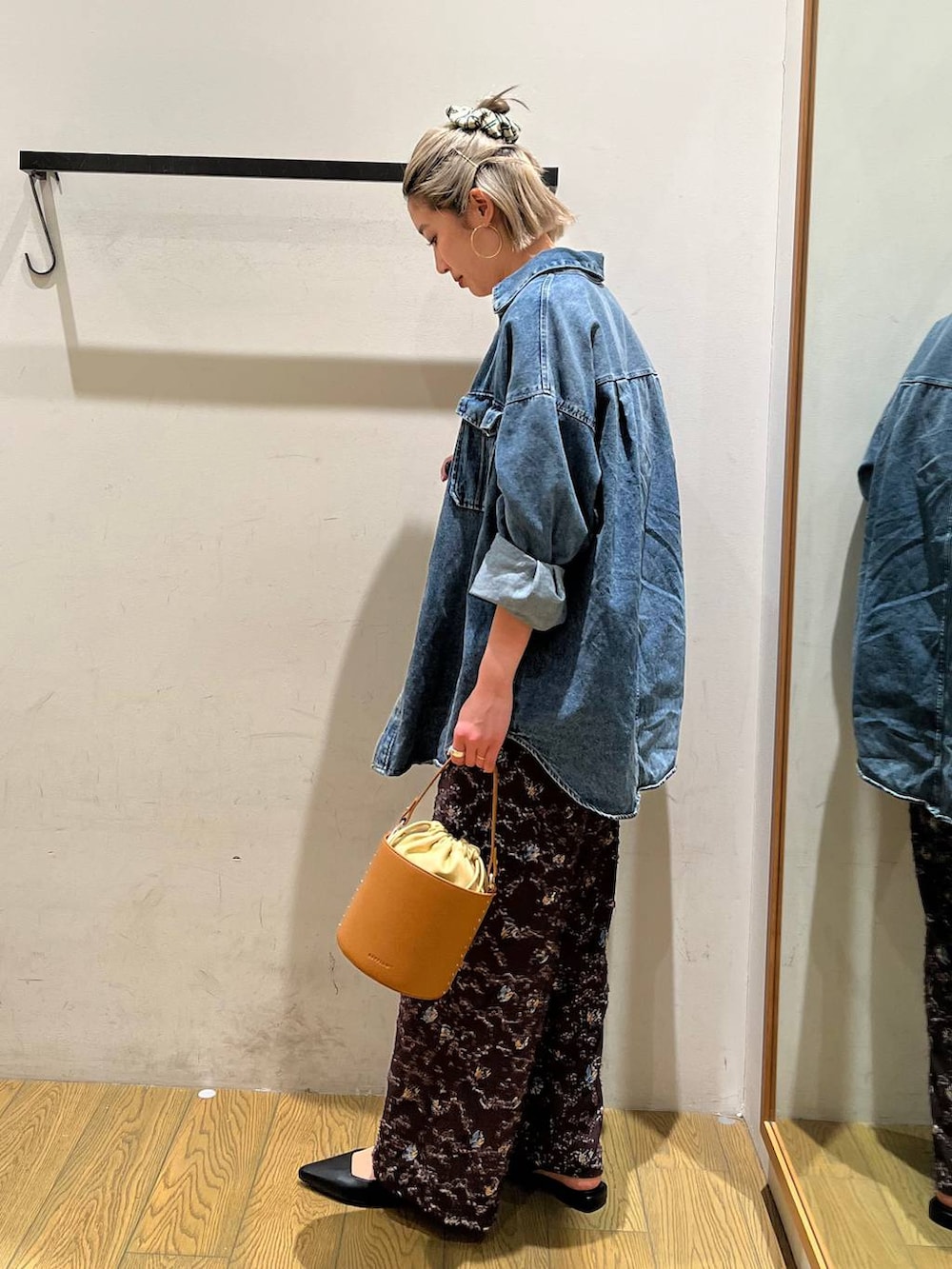 イエロー系のハンドバッグ、ブラック系のパンプス、ホワイト系のTシャツ/カットソーを着用したレディースの春コーディネートの2枚目の写真