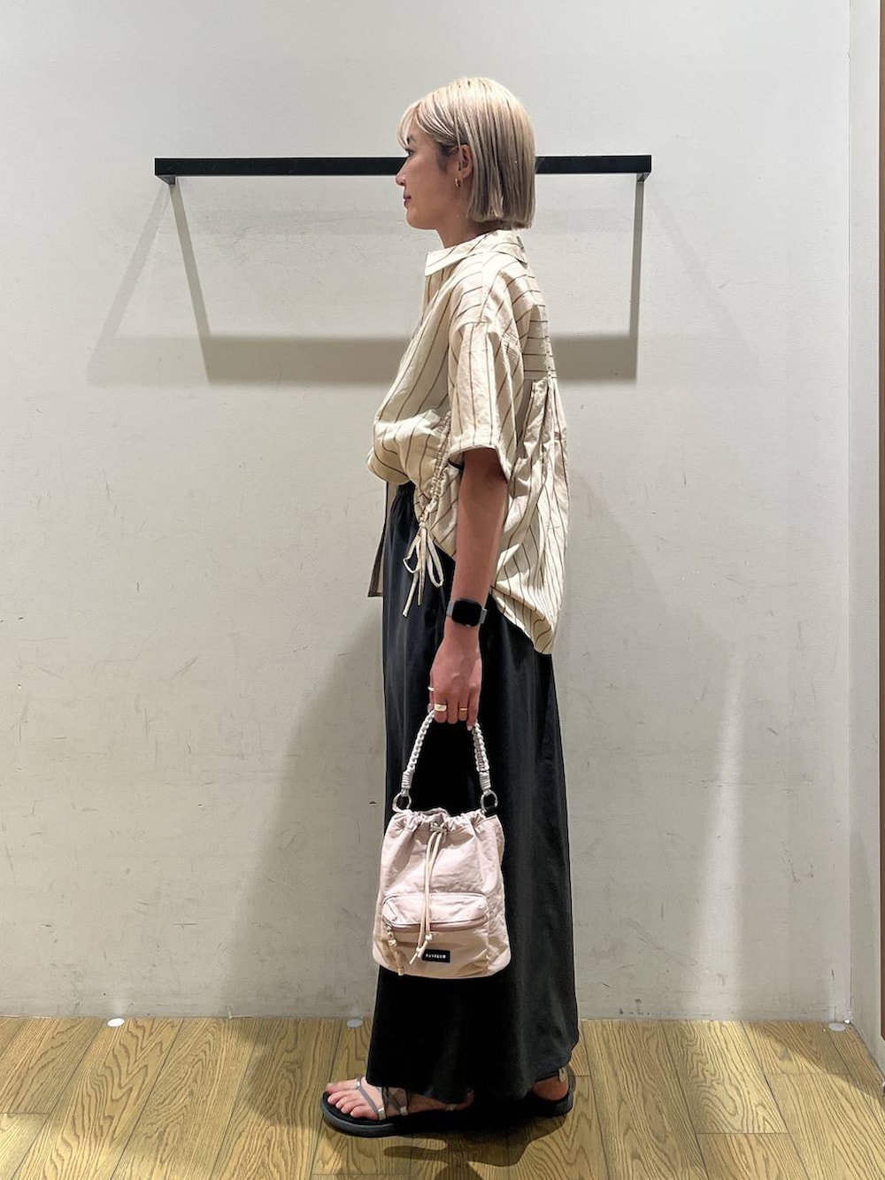 ベージュ系のショルダーバッグ、ベージュ系のシャツ/ブラウス、グレー系のスカートを着用したレディースの夏コーディネートの3枚目の写真