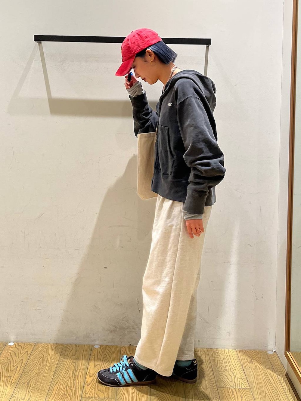 ブラック系のパーカー、ベージュ系のトートバッグ、ベージュ系のその他パンツを着用したレディースの冬コーディネートの2枚目の写真