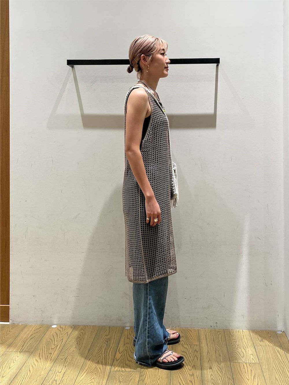 ブルー系のデニムパンツ、ベージュ系のワンピース、ベージュ系のショルダーバッグを着用したレディースの夏コーディネートの2枚目の写真