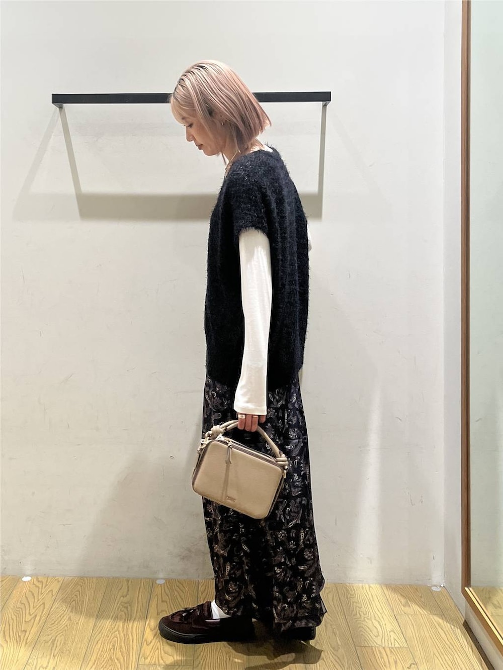 ブラック系のニット/セーター、ホワイト系のTシャツ/カットソー、ブルー系のスカートを着用したレディースの秋コーディネートの3枚目の写真