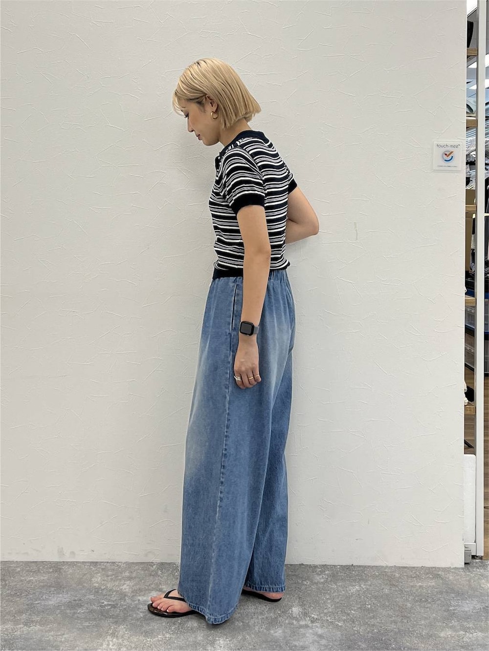 ブルー系のデニムパンツ、ブルー系のポロシャツを着用したレディースの夏コーディネートの3枚目の写真