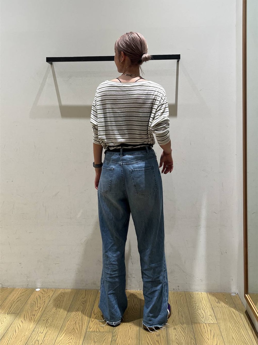 ブルー系のデニムパンツ、ブルー系のショルダーバッグ、ホワイト系のTシャツ/カットソーを着用したレディースの秋コーディネートの4枚目の写真