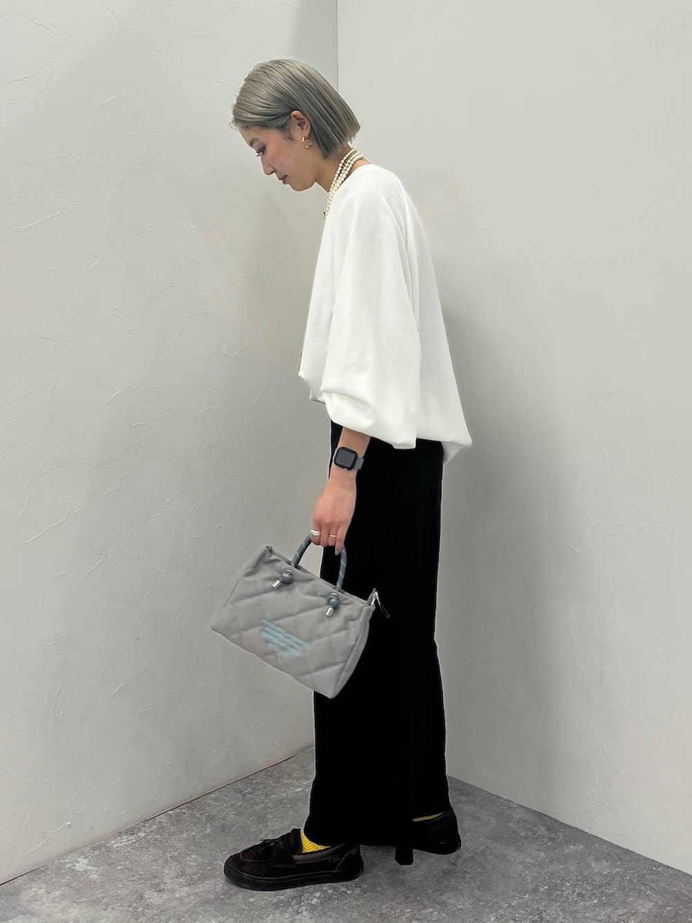 ホワイト系のスウェット、ブラック系のショルダーバッグを着用したレディースの冬コーディネートの2枚目の写真