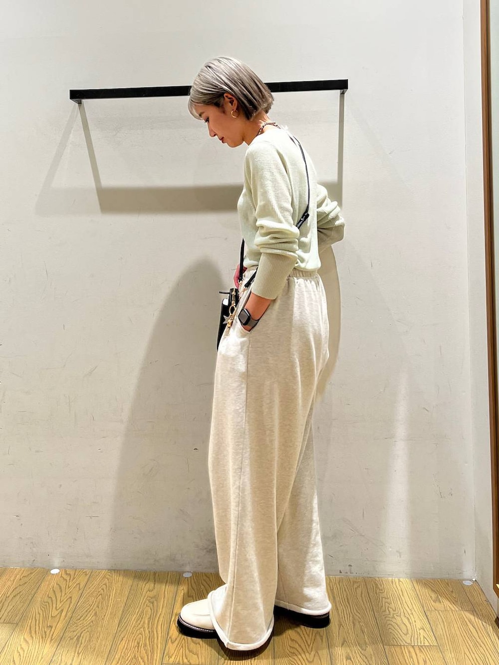 ホワイト系のローファー、グリーン系のカーディガン/ボレロ、ブラック系の財布を着用したレディースの春コーディネートの3枚目の写真