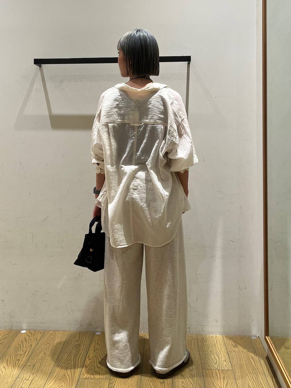 ホワイト系のシャツ/ブラウス、ブラウン系のタンクトップ、ブラック系のトートバッグを着用したレディースの春コーディネートの4枚目の写真