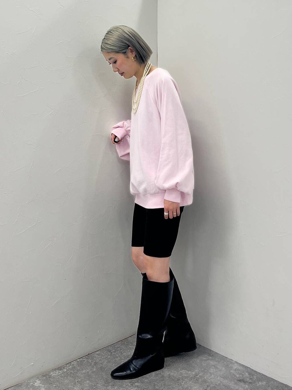 ブラック系のブーツ、ブラック系のその他パンツ、ピンク系のスウェットを着用したレディースの冬コーディネートの2枚目の写真