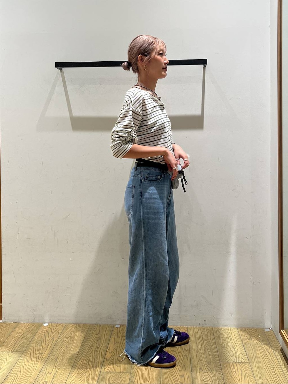 ブルー系のデニムパンツ、ブルー系のショルダーバッグ、ホワイト系のTシャツ/カットソーを着用したレディースの秋コーディネートの2枚目の写真