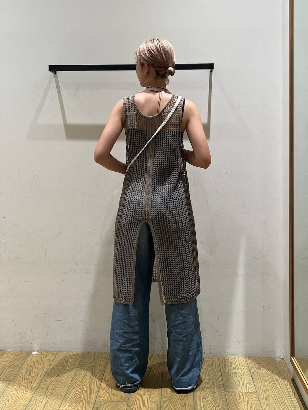 ブルー系のデニムパンツ、ベージュ系のワンピース、ベージュ系のショルダーバッグを着用したレディースの夏コーディネートの4枚目の写真