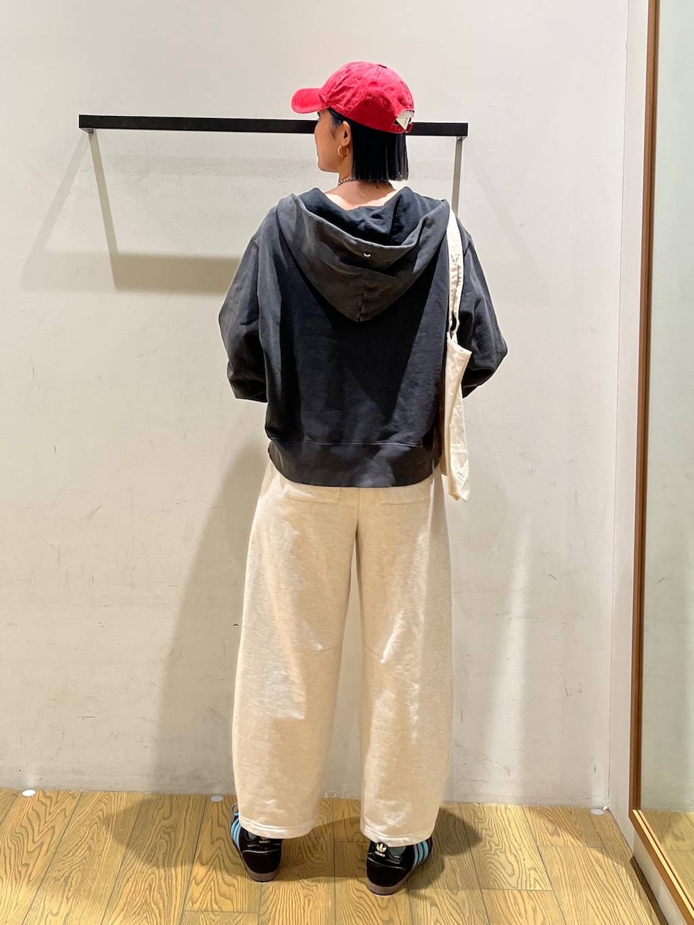 ブラック系のパーカー、ベージュ系のトートバッグ、ベージュ系のその他パンツを着用したレディースの冬コーディネートの4枚目の写真