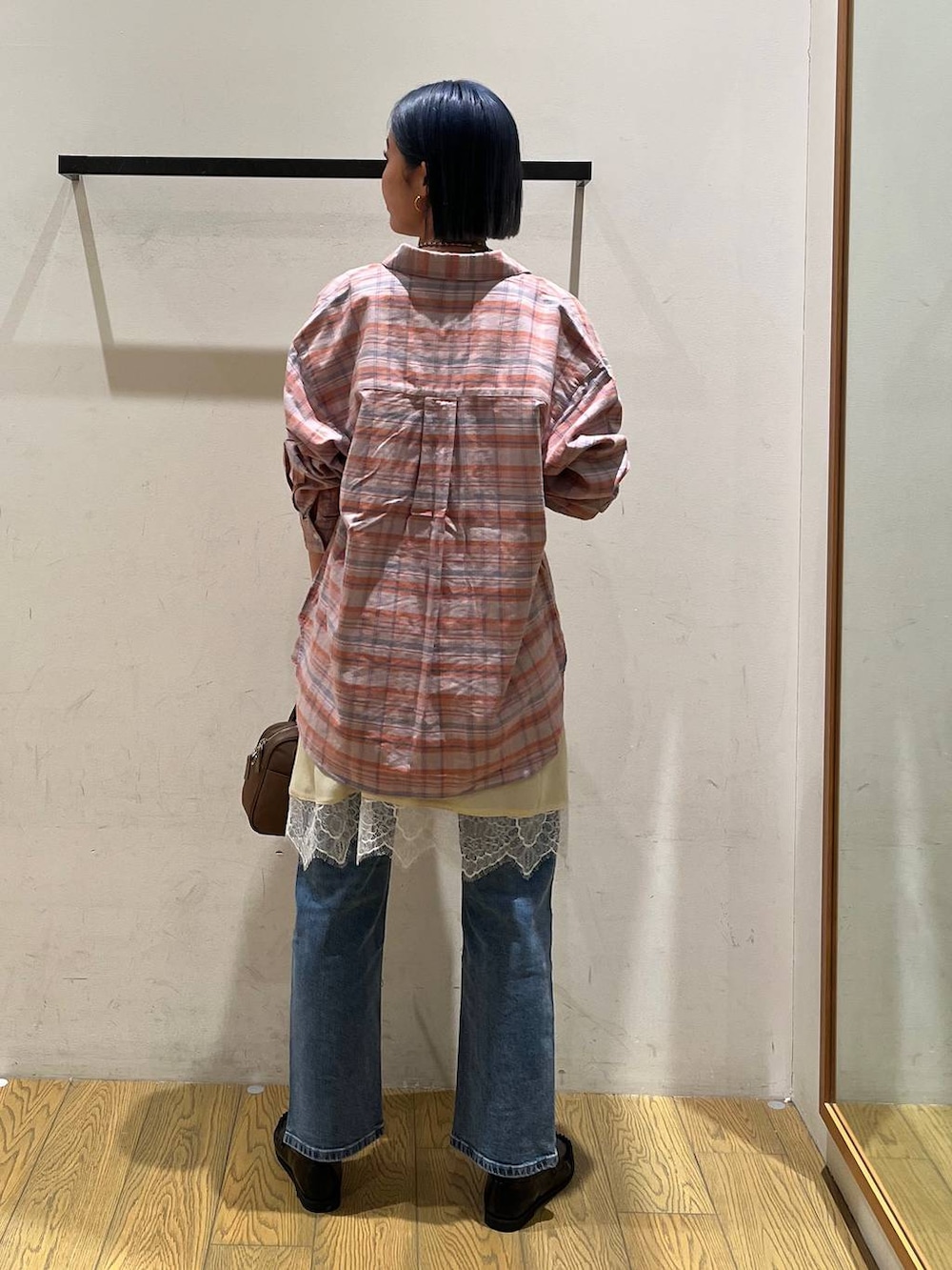 オレンジ系のシャツ/ブラウス、ブラウン系のハンドバッグ、ブラック系のローファーを着用したレディースの冬コーディネートの4枚目の写真