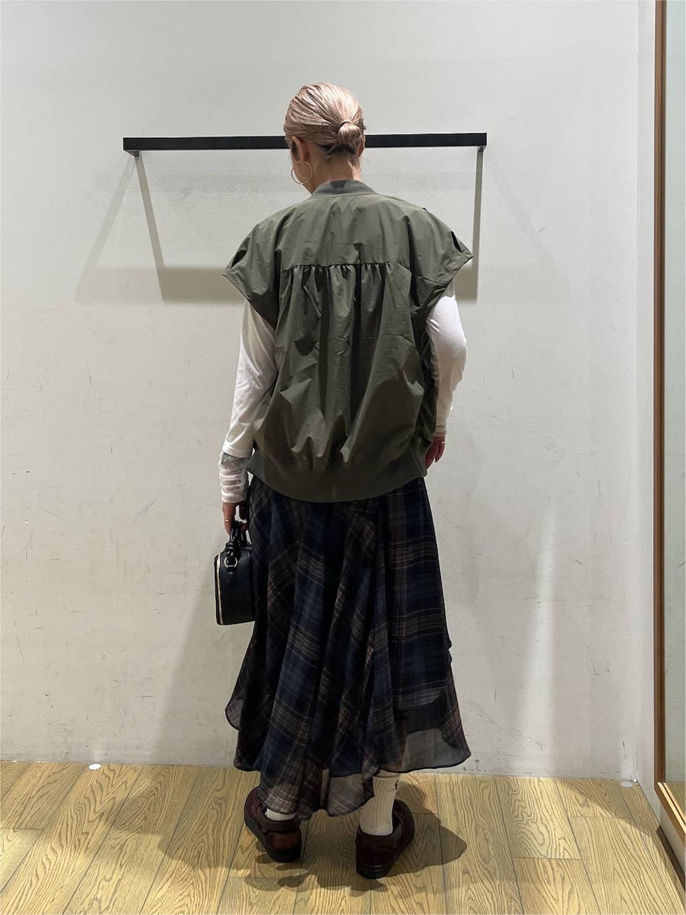 グリーン系のブルゾン、ホワイト系のTシャツ/カットソー、ブルー系のスカートを着用したレディースの夏コーディネートの4枚目の写真